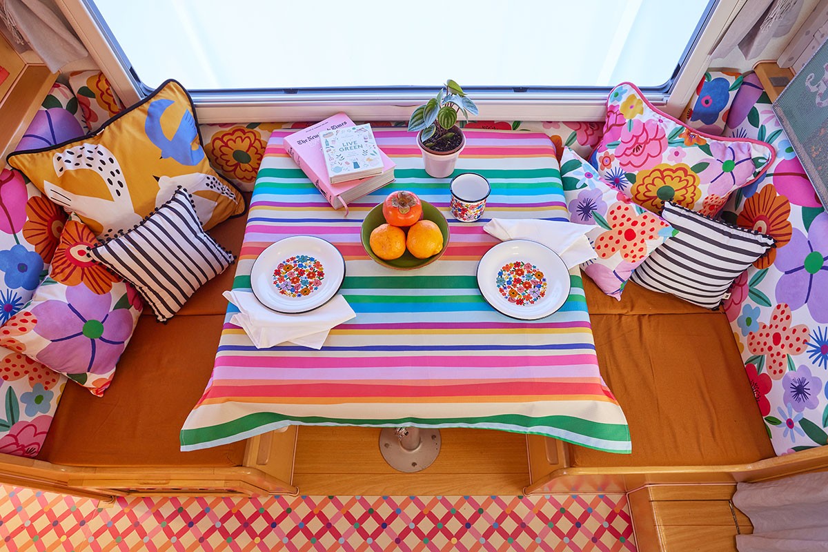 Imagem de cima da mesa de jantar. As louças combinam com o mobiliário e com a arquitetura do espaço (Foto: Divulgação / Fotógrafo / Mooui)