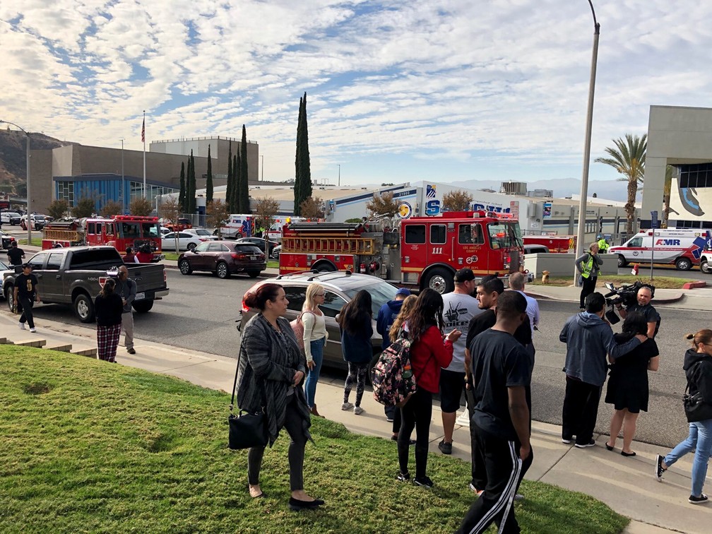 Pessoas aguardam alunos e informações do lado de fora da escola de ensino médio de Saugus, na Califórnia, depois de um tiroteio nesta quinta-feira (14). — Foto: Marcio Jose Sanchez/AP