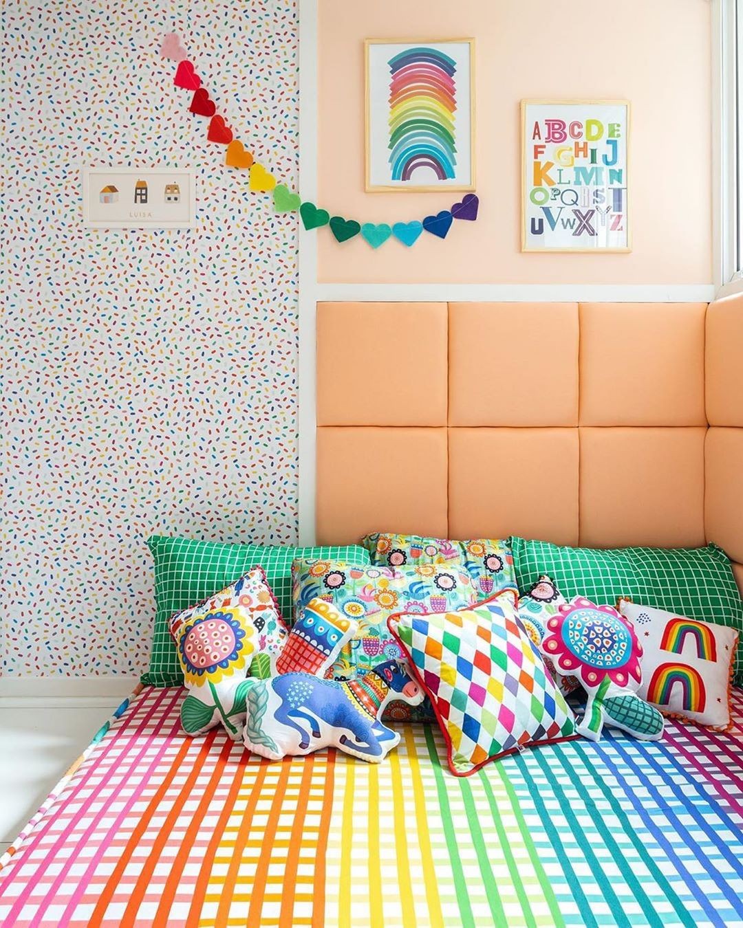 Quarto para as crianças decorado, colorido, disposto com almofadas e um colchão confortável para brincadeira, e estudo das crianças.