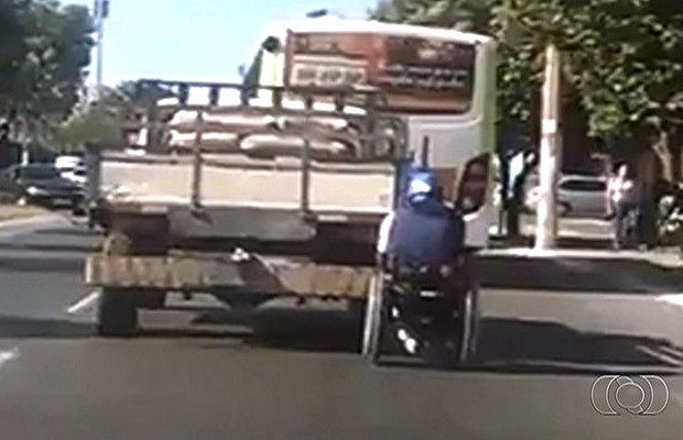 Homem em cadeira de rodas pega carona em caminhonete em Aparecida de Goiânia, Goiás (Foto: Reprodução/ TV Anhanguera)