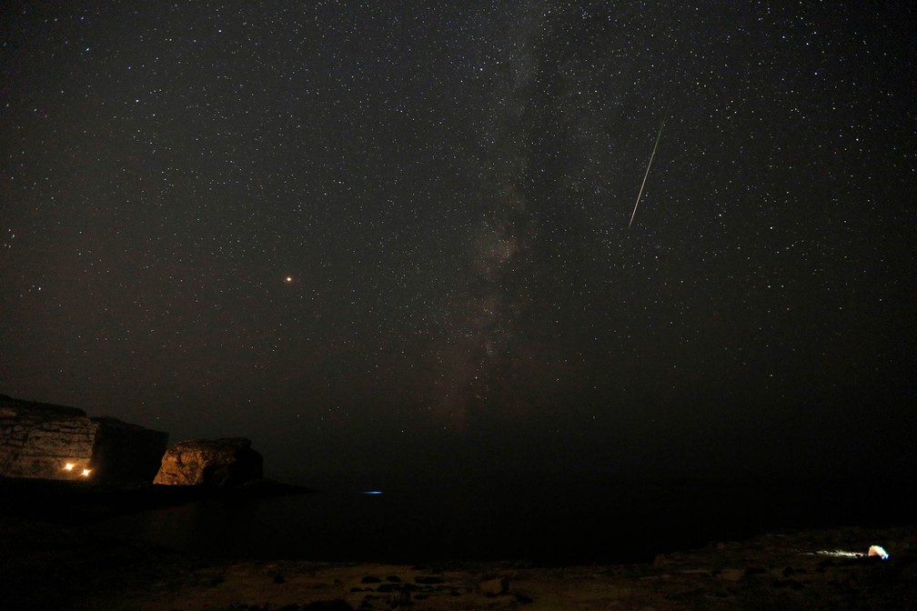 Meteoro corta o céu com a Via Láctea vista à sua esquerda, nas primeiras horas da manhã, durante a chuva de meteoros Perseidas. Vista de Dwejra, perto da vila de San Lawrenz, na ilha de Gozo, em Malta (Foto: Darrin Zammit Lupi/Reuters)
