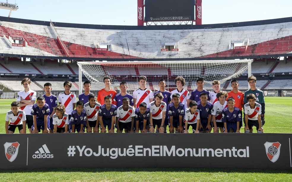 Jovens do time ‘Javalis Selvagens’, que ficaram presos em caverna na Tailândia, posam para foto antes de jogo contra equipe juvenil do River Plate no Estádio Monumental, em Buenos Aires, no domingo (7) — Foto: Eitan Abramovich/Pool/AFP