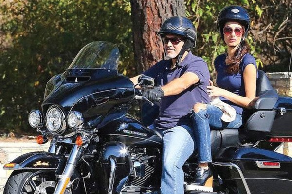 O ator George Clooney com a esposa na moto que ele doou para caridade (Foto: Divulgação/EBay)