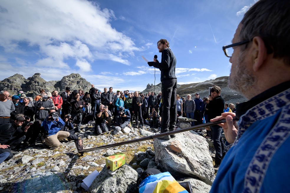 Pessoas participam de cerimônia para marcar a 'morte' da geleira Pizol no domingo (22) em Mels, na Suíça. — Foto: Fabrice Coffrini/AFP