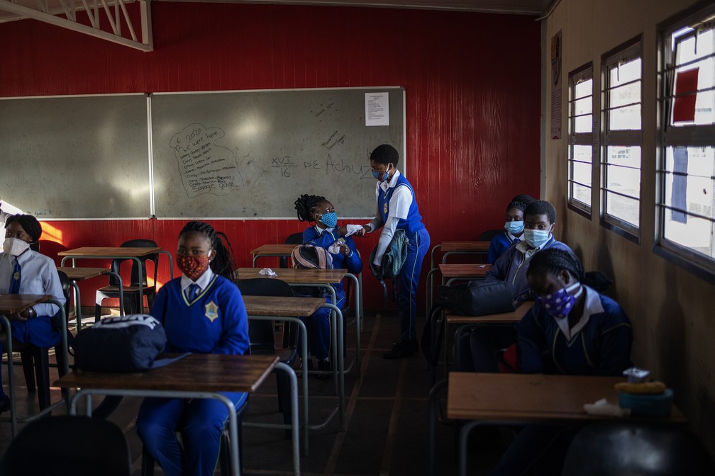 De máscara, com distanciamento e produtos de limpeza, aulas presenciais voltaram em cidade na África do Sul nesta segunda (8) — Foto: Michele Spatari/AFP
