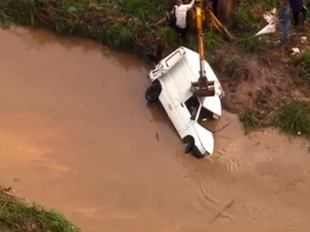 Carro é retirado com ajuda de retroescavadeira em Ferraz de Vasconcelos após ser arrastado pela água durante temporal  (Foto: Reprodução TV Globo)