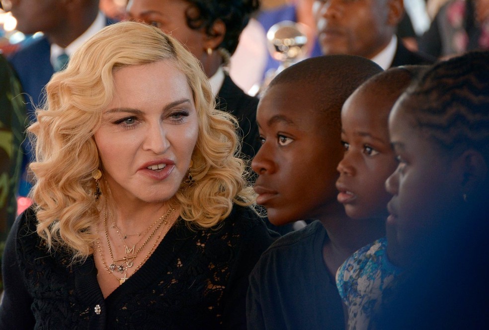 A cantora americana Madonna conversa com seus filhos adotivos David, Stella e Mercy durante inauguração de ala em hospital no Malawi (Foto: Thoko Chikondi/AP)