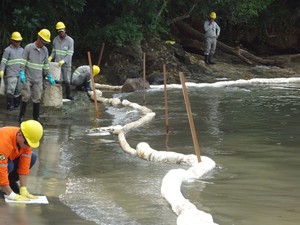 Funcionários da Petrobras trabalham na contenção e limpeza da Praia das Cigarras, em São Sebastião. (Foto: Divulgção/Capitania dos Portos)