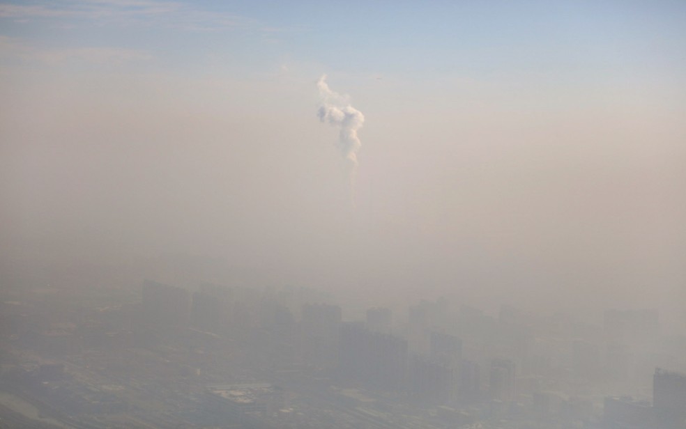 A chaminé de uma fábrica é vista em meio à poluição do ar em Pequim, na China. — Foto: Reuters