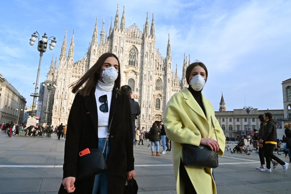 Mulheres usam máscaras para se proteger do coronavírus na praça da catedral de Milão, na Itália, em 23 de fevereiro de 2020 — Foto: Andreas Solaro / AFP