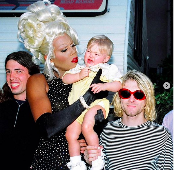 Frances Bean Cobain ainda criança no colo da drag queen Ru Paul e ladeada por Dave Grohl e Kurt Cobain (1967-1994) (Foto: Instagram)