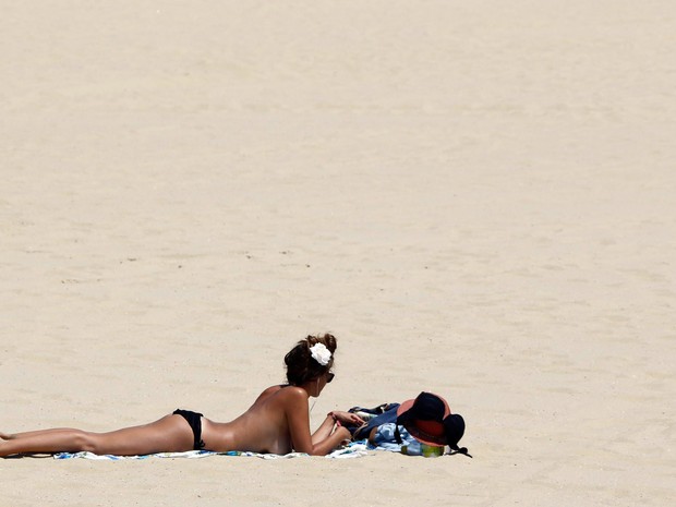 Mulher toma sol em uma praia durante dia quente e ensolarado em Arcachon, perto de Bordeaux, na França (Foto: Regis Duvignau/Reuters)