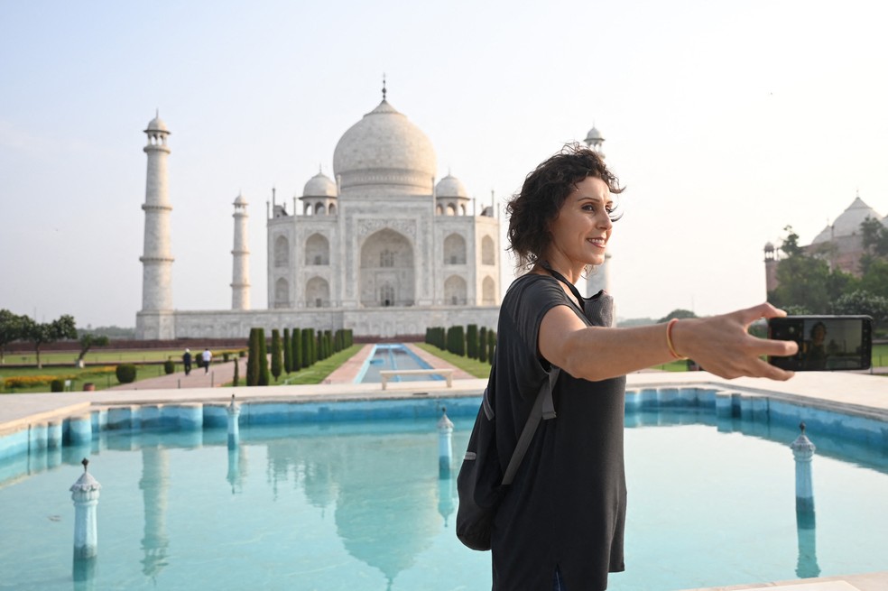 A brasileira Melissa Dalla Rosa tira fotos de lembrança no Taj Mahal no dia da reabertura aos visitantes em Agra, na Índia, em 16 de junho de 2021 — Foto: Money Sharma/AFP 