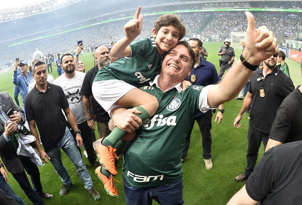 Bolsonaro comemora título com filho de vice do clube no ombro — Foto: Marcos Ribolli
