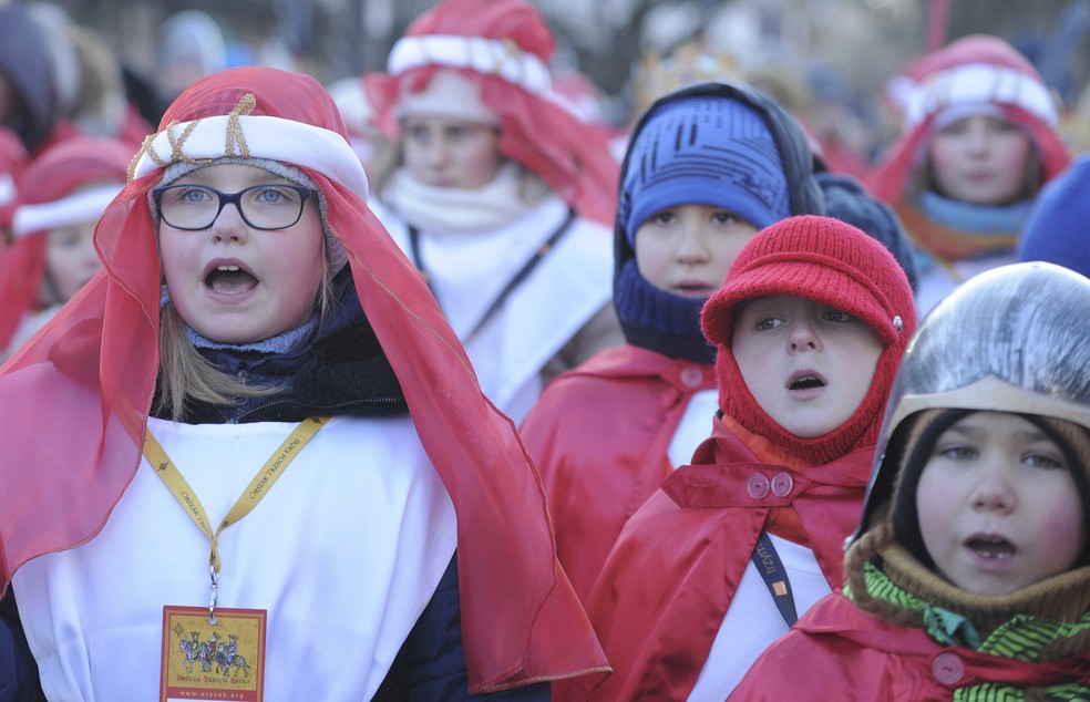 Alunos cantam durante as celebrações da Epifania em dia com temperatura de -12ºC, em Varsóvia, na Polônia (Foto: AP Photo/Alik Keplicz)