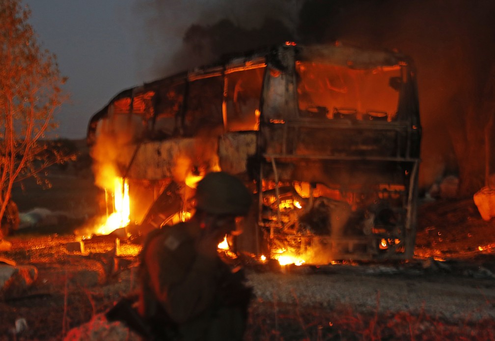 Ã”nibus pegou fogo perto do kibbutz de Kfar Aza apÃ³s ser atingido por foguete lanÃ§ado de Gaza, segundo Israel â€” Foto: AFP/Kahana