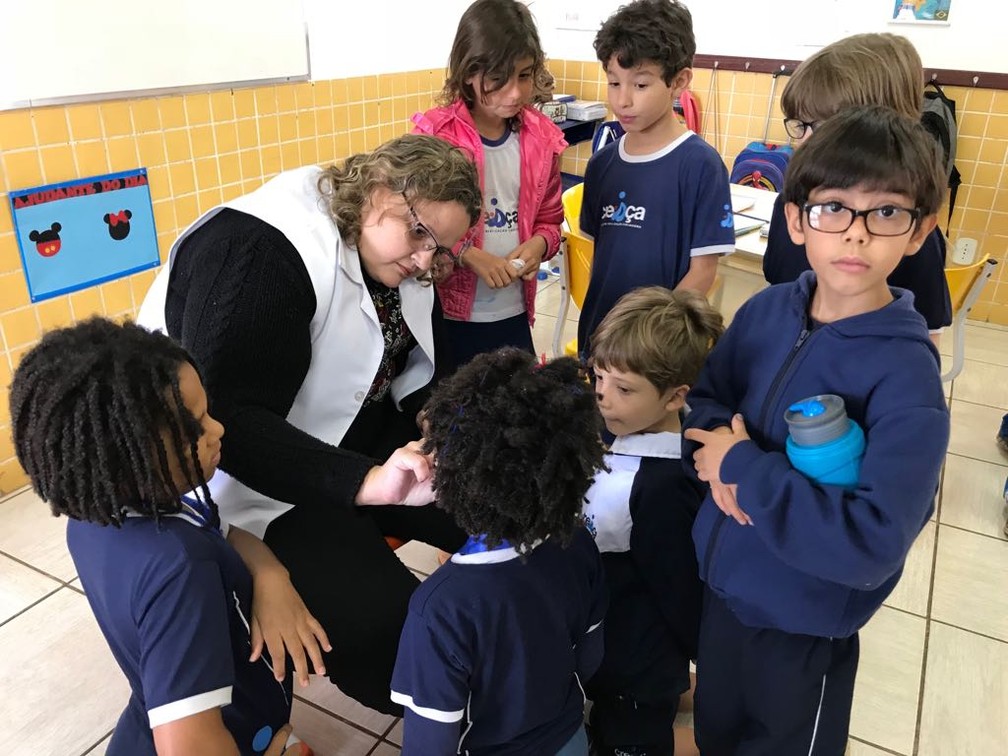 A professora Cynthia Rosal cola esparadrapos nas crianças da turma de Miguel Gadelha ao menos duas vezes por semana (Foto: Ana Luiza de Carvalho/G1)