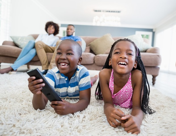 Crianças assistem TV com a família (Foto: Wavebreakmedia/Thinkstock)
