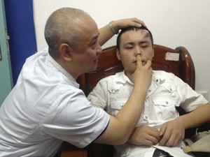 Médico examina nariz de paciente, cuja cartilagem foi corroída por uma infecção não tratada. (Foto: Reuters/Stringer)