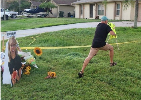 O pai de Brian Laundrie removendo o cartaz instalando no jardim de sua casa (Foto: Reprodução/Twitter)