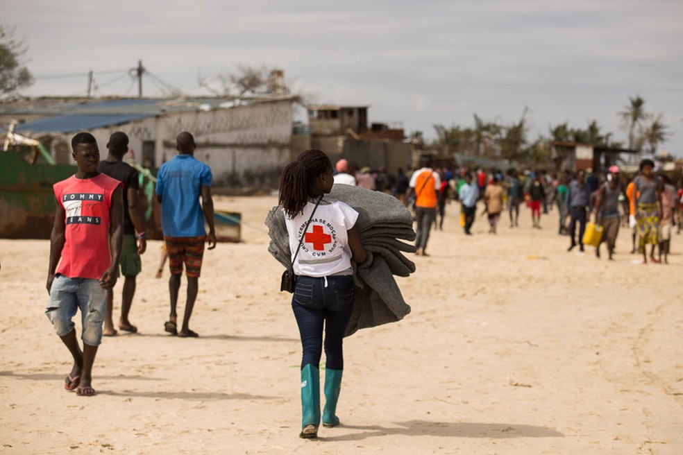 A foto, do dia 21 de março, mostra uma voluntária da Cruz Vermelha moçambicana carregando mantimentos para sobreviventes do ciclone Idai, na Beira, em Moçambique. — Foto: Red Cross Red Crescent Climate Centre/Handout via Reuters