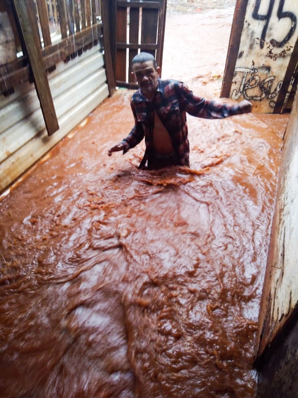 Morador ficou com gua na cintura ao tentar entrar em um barraco em Campo Grande.   Foto: Reproduo