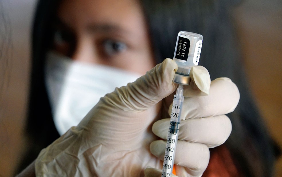 Funcionário prepara vacina contra Covid para aplicação em jovem em Quito, no Equador, em foto de 13 de setembro — Foto: Rodrigo Buendia/AFP