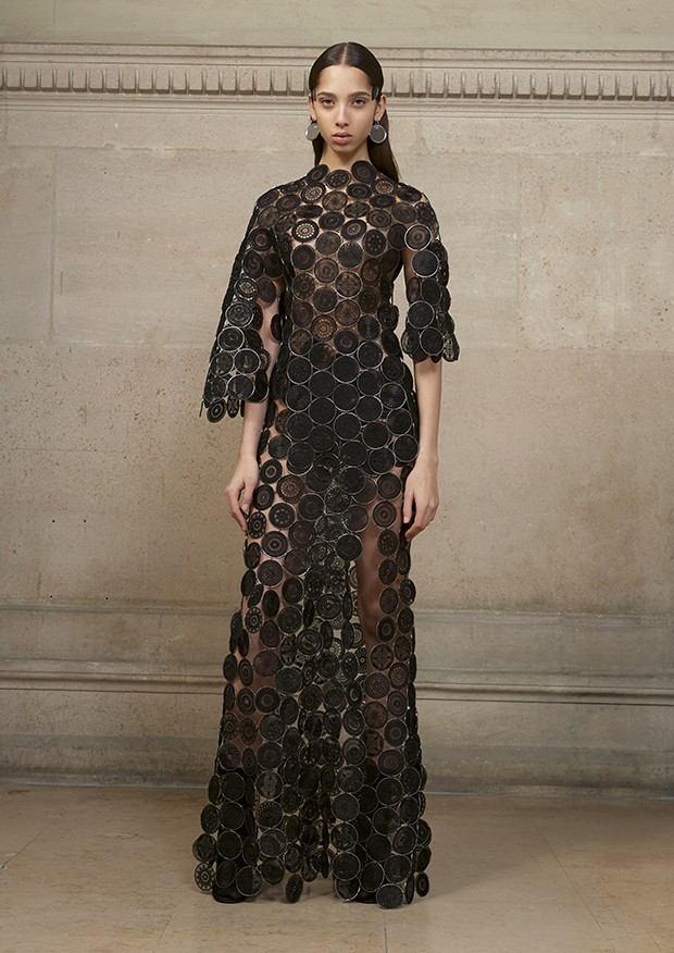 Yasmin wears a long asymmetric dress made entirely of fine metal rings covered with organza and hand-embellished with geometric motifs (Foto: Givenchy)