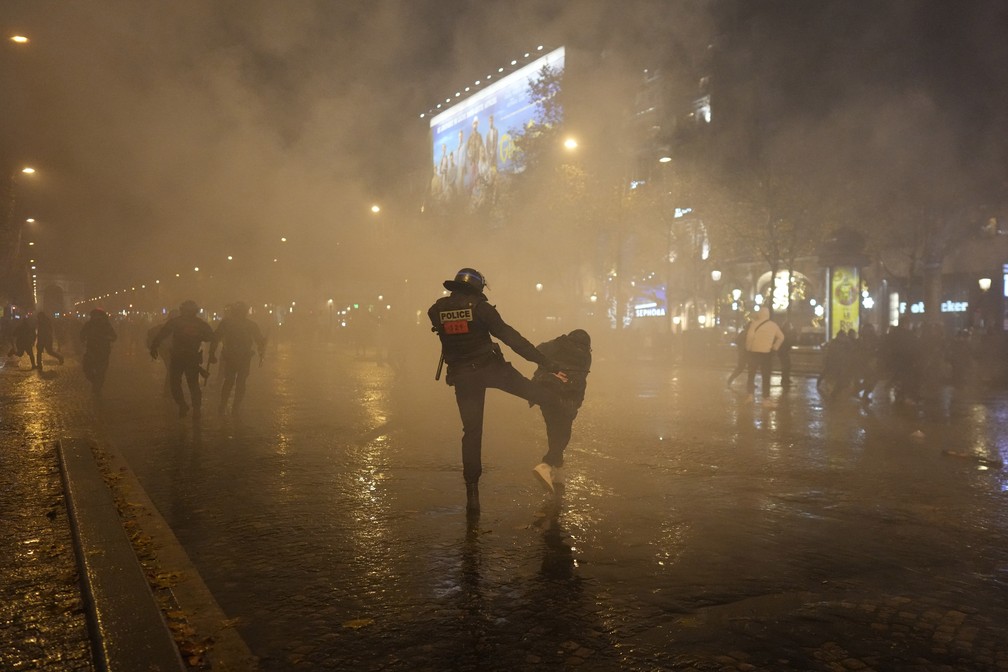 Policial chuta um torcedor em Paris após a final da Copa do Mundo entre Argentina e França em 18 de dezembro de 2022 — Foto: Thibault Camus/AP