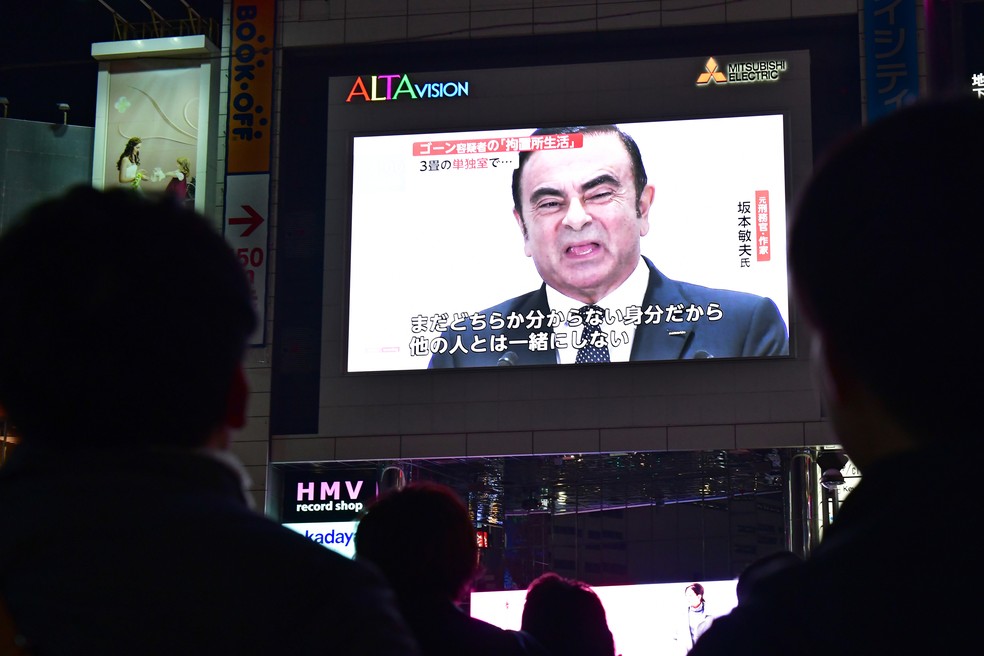 Japoneses assistem reportagem sobre Carlos Ghosn nas ruas de Tóquio no final de outubro — Foto: Kazuhiro Nogi/AFP