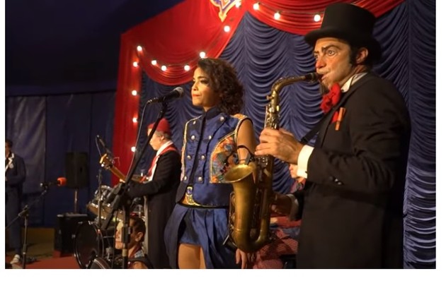 Luciana, que é a sócia-fundadora do circo, também canta na banda (Foto: Reprodução/Youtube)