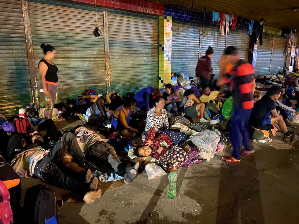 Famílias dormem em calçadas para se abrigar das chuvas — Foto: Caíque Rodrigues/G1 RR