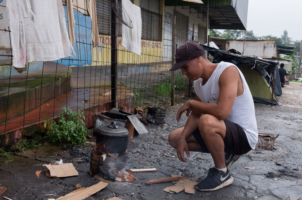 Imigrantes fazem comida em fogões improvisados (Foto: Inaê Brandão/G1 RR)