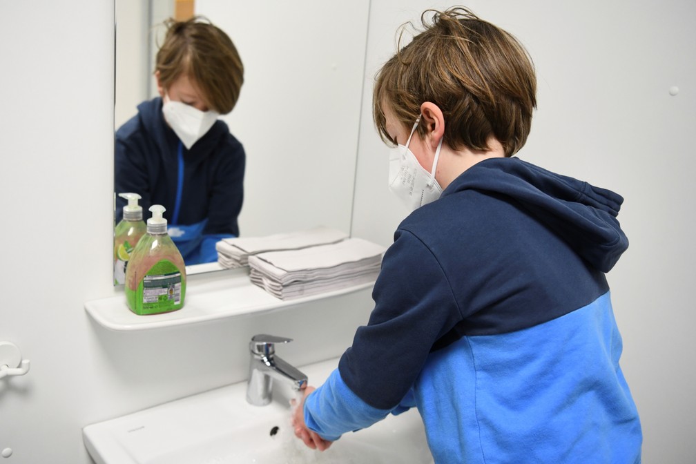 Foto mostra criança lavando as mãos em escola primária de Berlim, no primeiro dia de retorno em meio ao relaxamento das restrições contra a Covid-19, no dia 22 de fevereiro. — Foto: Annegret Hilse/Reuters