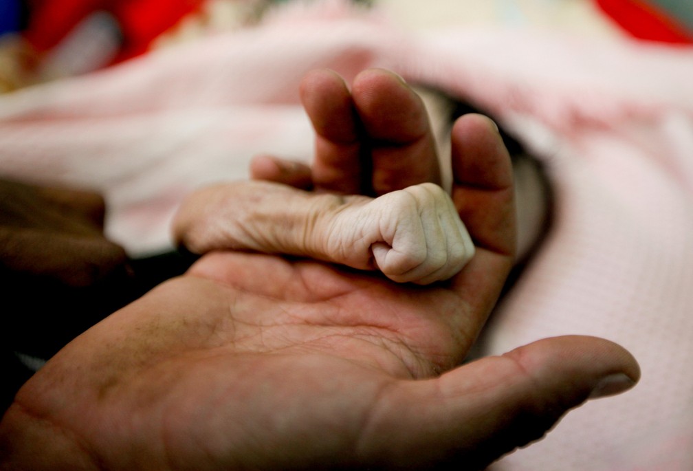 15 de novembro â Saleh Hassan al-Faqeh segura a mÃ£o de sua filha Hajar, de 4 meses, morta por desnutriÃ§Ã£o na enfermaria do hospital al-Sabeen, em SanÃ¡, no IÃªmen â Foto: Mohamed al-Sayaghi/Reuters