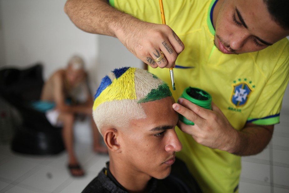 O barbeiro Washington Rodrigo faz o Corte do Hexa num cliente durante ação com o Itaú