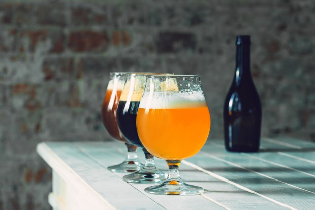 Glasses of different kinds of dark and light beer on wooden table in line. Cold delicious drinks are prepared for a big friend's party. Concept of drinks, fun, meeting, oktoberfest. (Foto: Freepik)