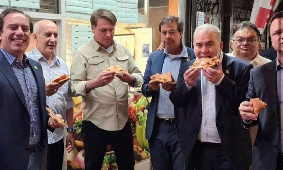 Bolsonaro come pizza na calçada em Nova York, com ministros, em setembro: sem estar vacinado, presidente não poderia entrar em restaurantes da cidade