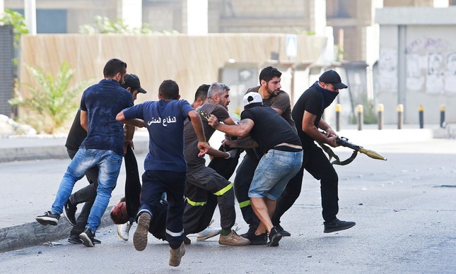 Homens retiram um ferido após um tiroteio em Beirute