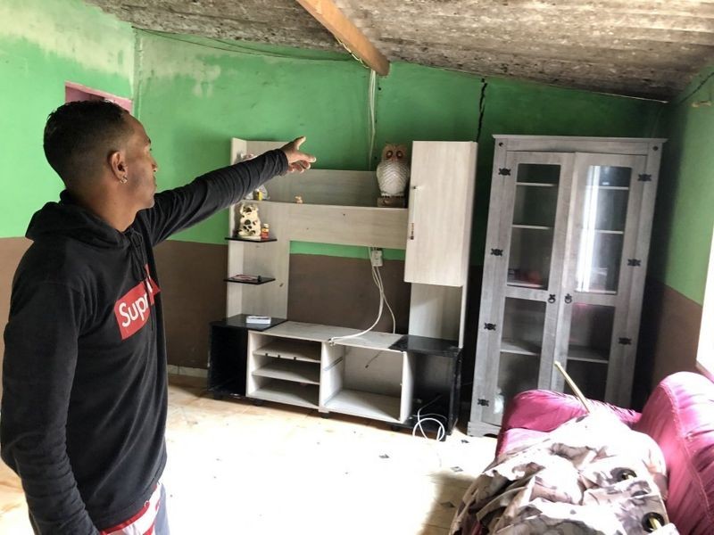 O comerciante Alexandre Gregório mostra rachadura na parede da casa de sua família (Foto: Leandro Machado via BBC News Brasil)