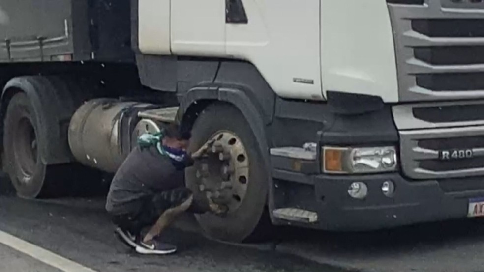 Motoristas esvaziam pneu de caminhão para não retirar veículo da pista  — Foto: Reprodução/TV Globo