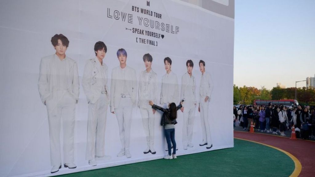 Fã tenta abraçar foto do grupo sul-coreano BTS antes de show em Seul que marcou final da turnê mundial da banda (Foto: ED JONES/AFP VIA GETTY IMAGES)