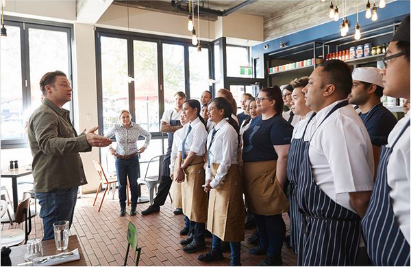 O chef e apresentador de TV Jamie Oliver com funcionários de uma unidade de seu restaurante (Foto: Instagram)