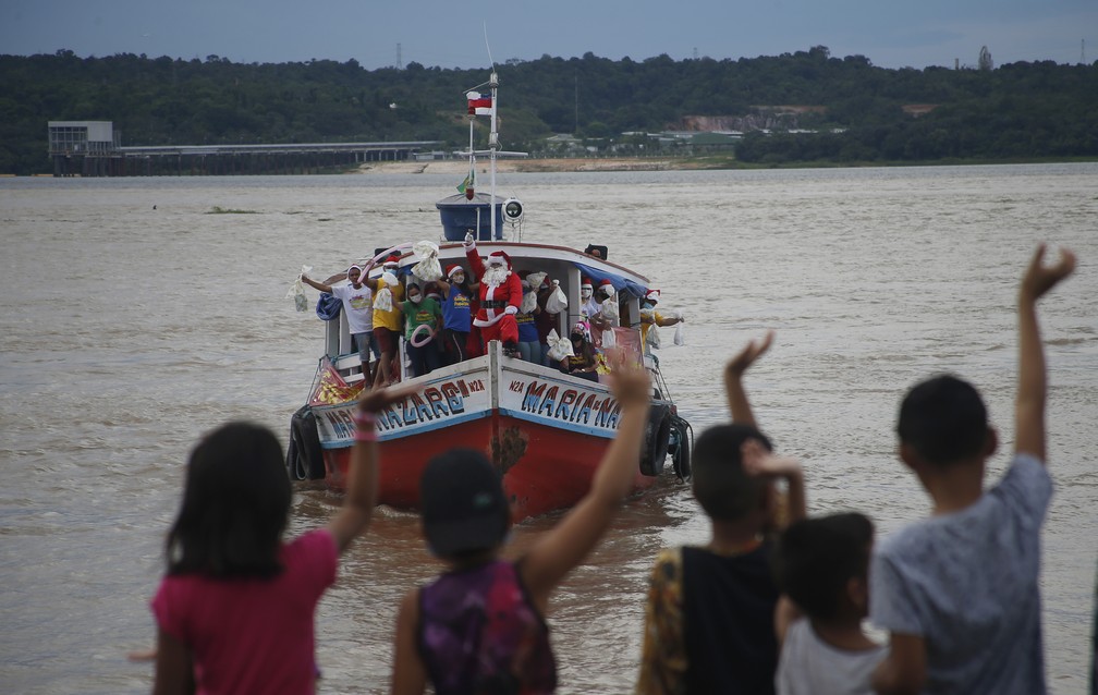 18 de dezembro - Um homem vestido de Papai Noel navega no rio Amazonas em um barco para visitar comunidades ribeirinhas para distribuir presentes para crianças, perto de Careiro da Várzea, no Amazonas  — Foto: Edmar Barros/AP