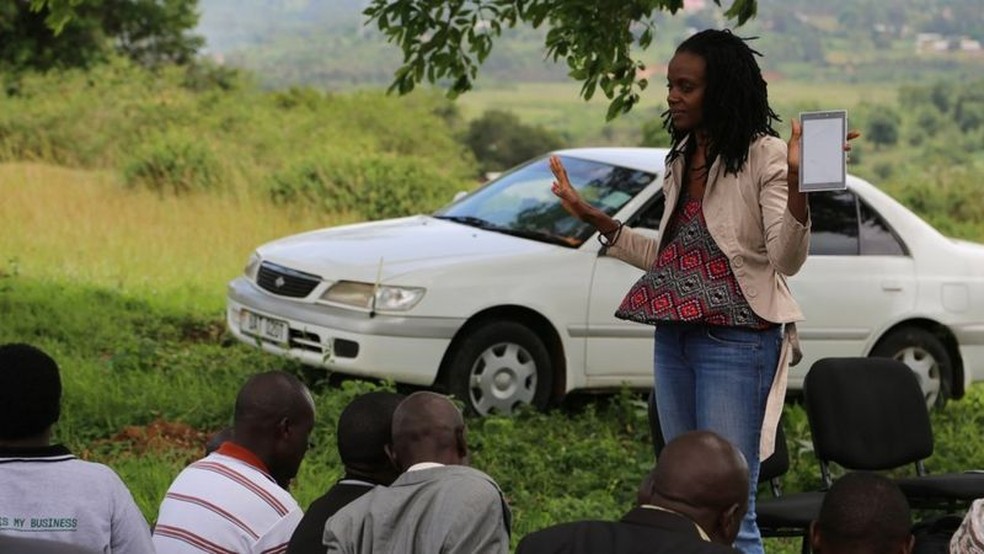 Dr. Nakalembe fala a fazendeiros sobre como usar um aplicativo para enviar informações sobre as plantações — Foto: Catherine Nakalembe via BBC