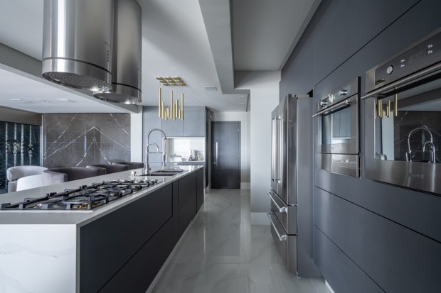 Os armários planejados da cozinha são cinza, seguindo a paleta neutra do apartamento 