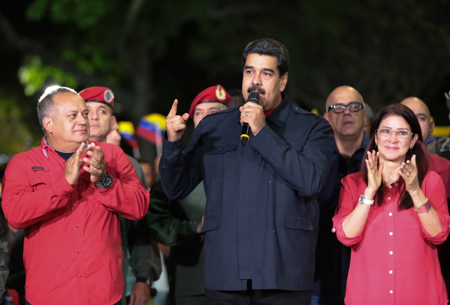 Presidente venezuelano, Nicolás Maduro (centro), discursa ao lado da primeira-dama, Cilia Flores, e Diosdado Cabello em Caracas