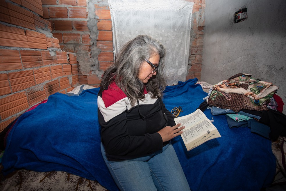 A comerciante Claudia di Silverio lendo em sua casa, em Paraisópolis (SP) — Foto: Fábio Tito/g1