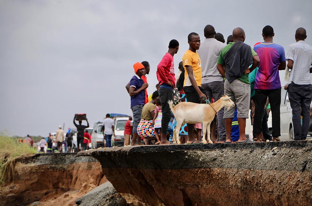 Moradores aguardam em estrada que liga Beira e Chimoio, no distrito de Nhamatanda, em Moçambique, na terça-feira (19)  — Foto: Adrien Barbier / AFP