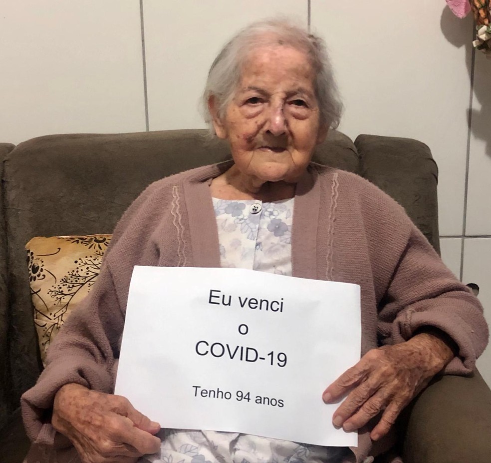 Dona Maria segura placa para mostrar que vence a Covid-19 em Nova Granada  — Foto: Arquivo Pessoal 